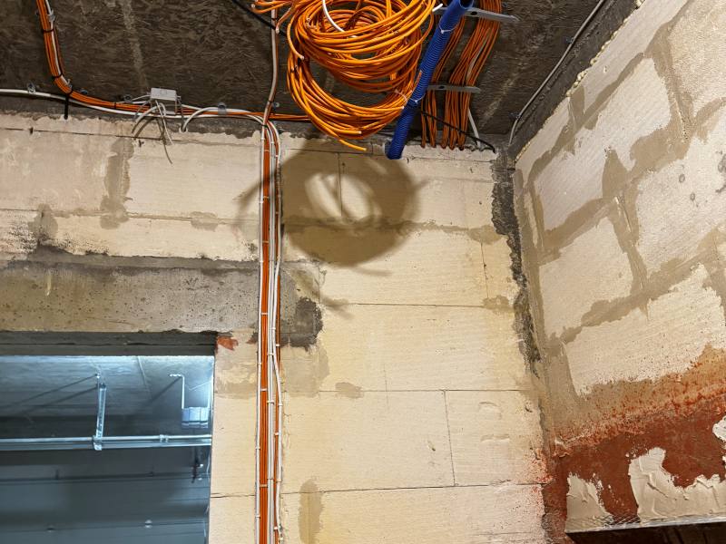 Zapas przewodów instalacji LAN i kamer zwinięty pod stropem nad miejscem przyszłej szafy rack